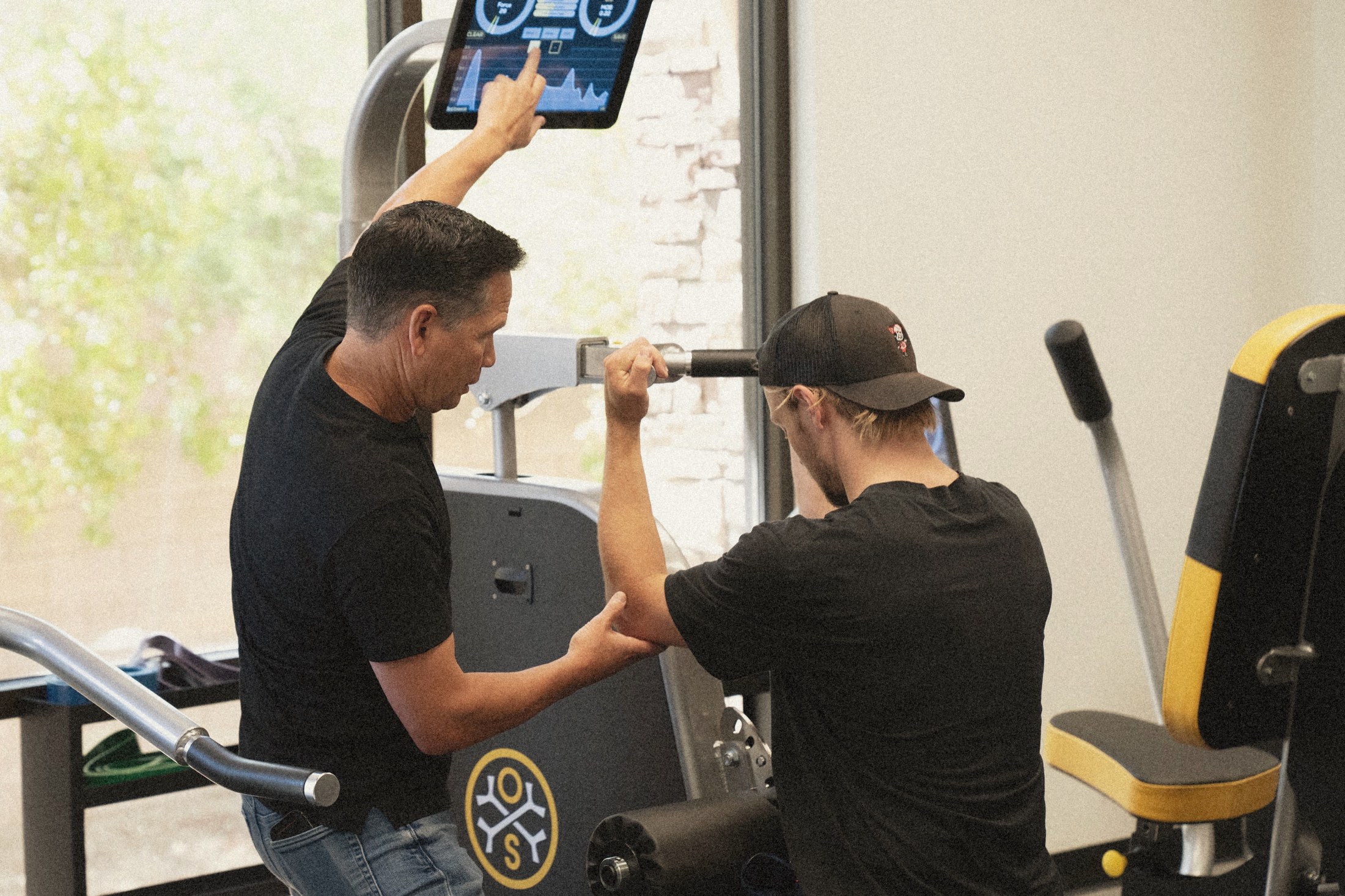 A Clay team member measuring a seated member's strength and movement during the Baseline assessment.