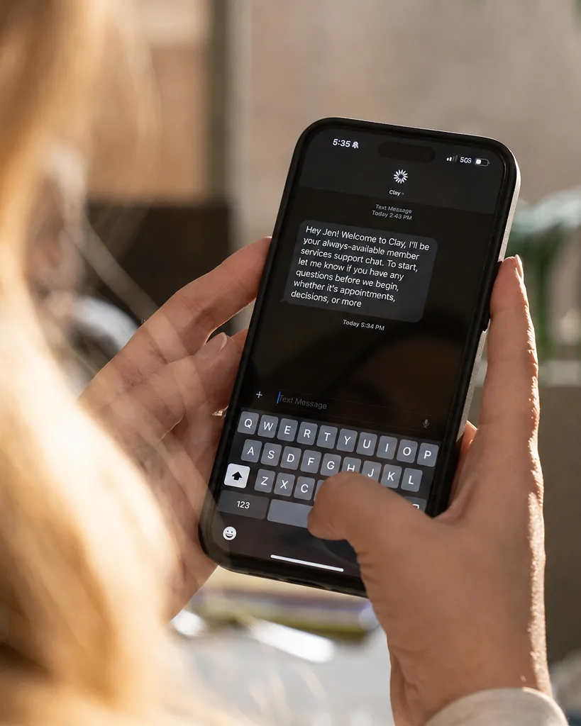 A member reading a welcome text from Clay Support.